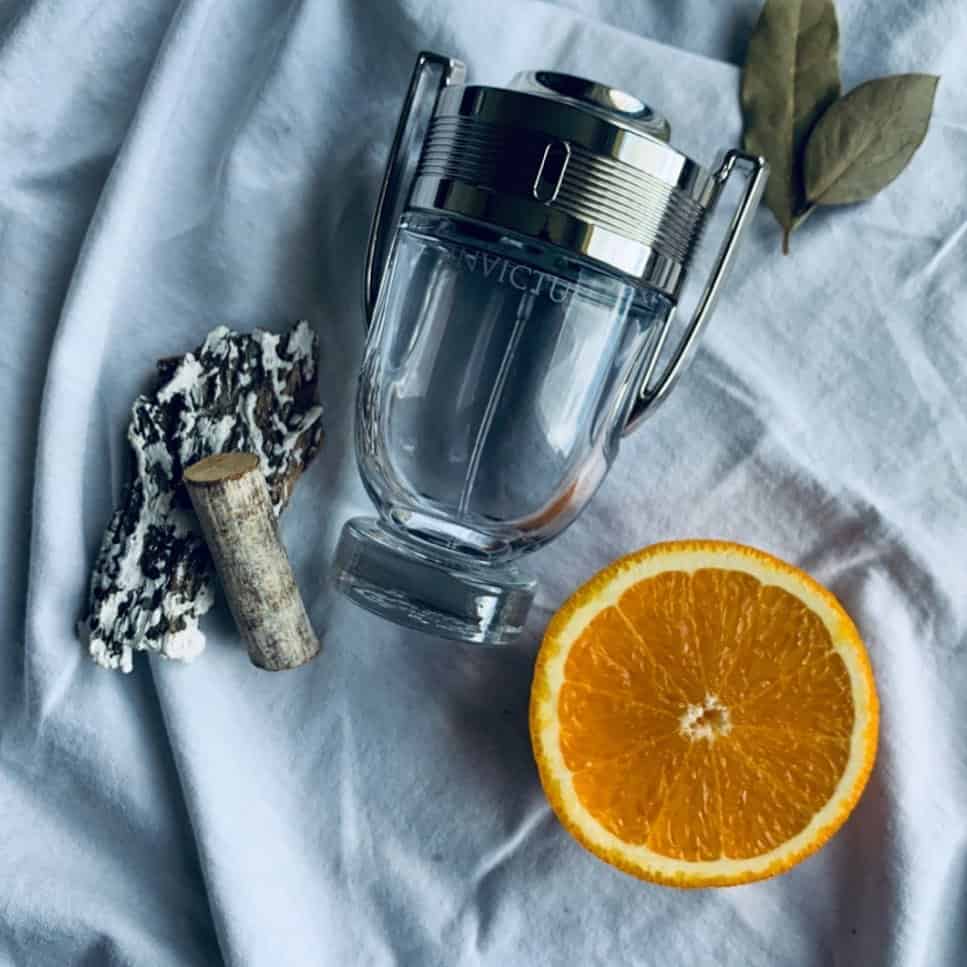a bottle of invictus eau de toilette by paco rabanne and some raw ingredients