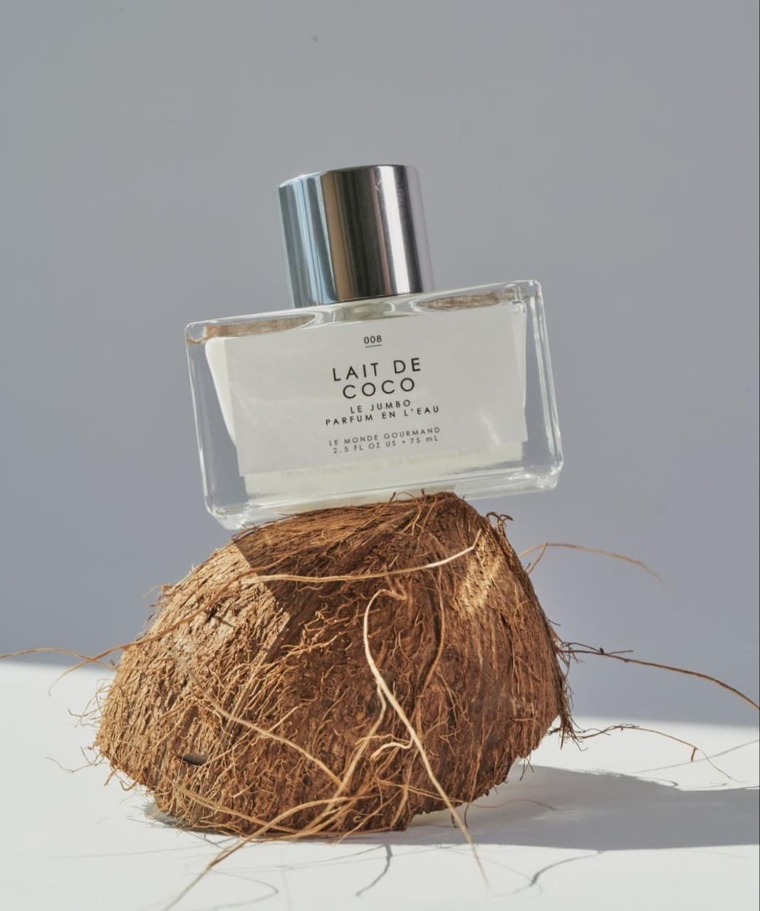 a bottle of Le Monde Gourmand Lait De Coco on top of a halfed coconut