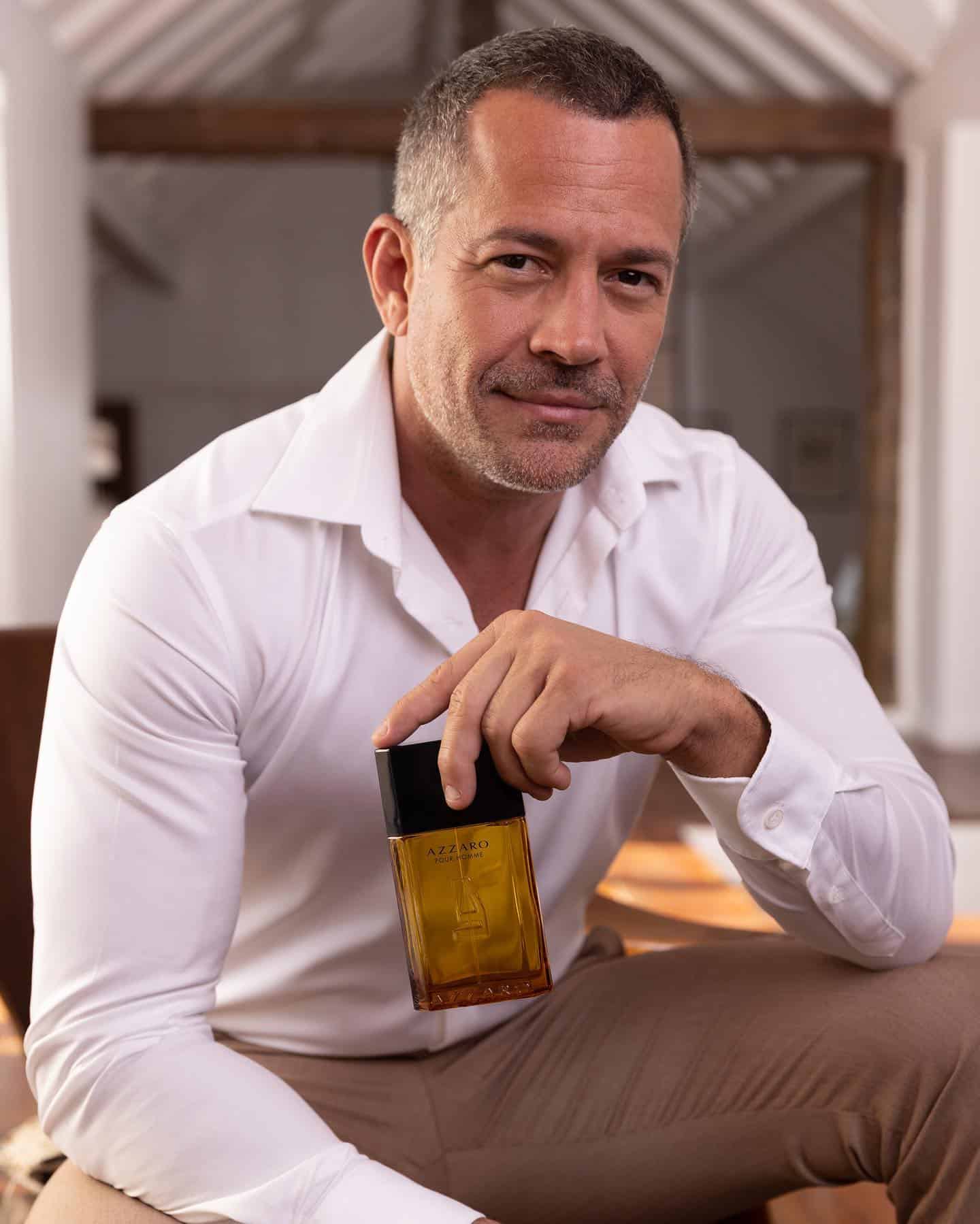 man holding a bottle of pour homme by azzaro