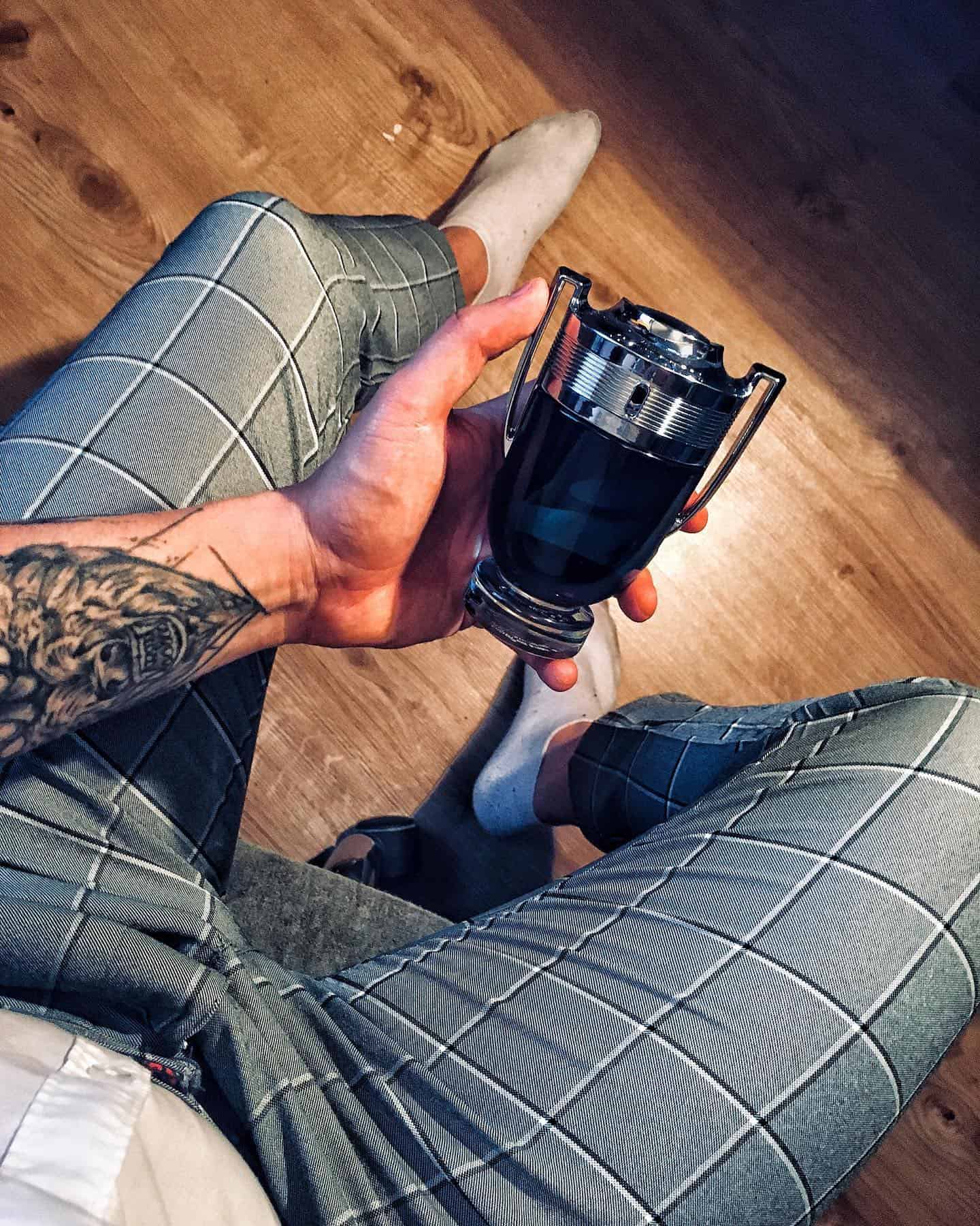 man holding a bottle of invictus legend by paco rabanne