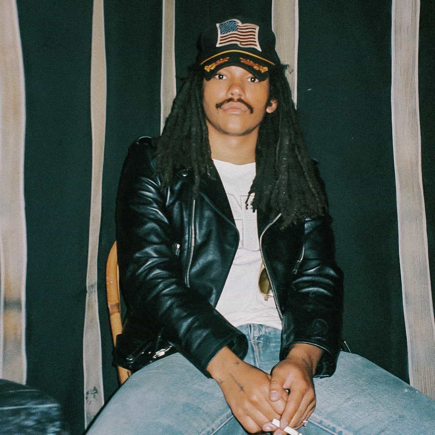 man in a biker jacket holding a cigarette