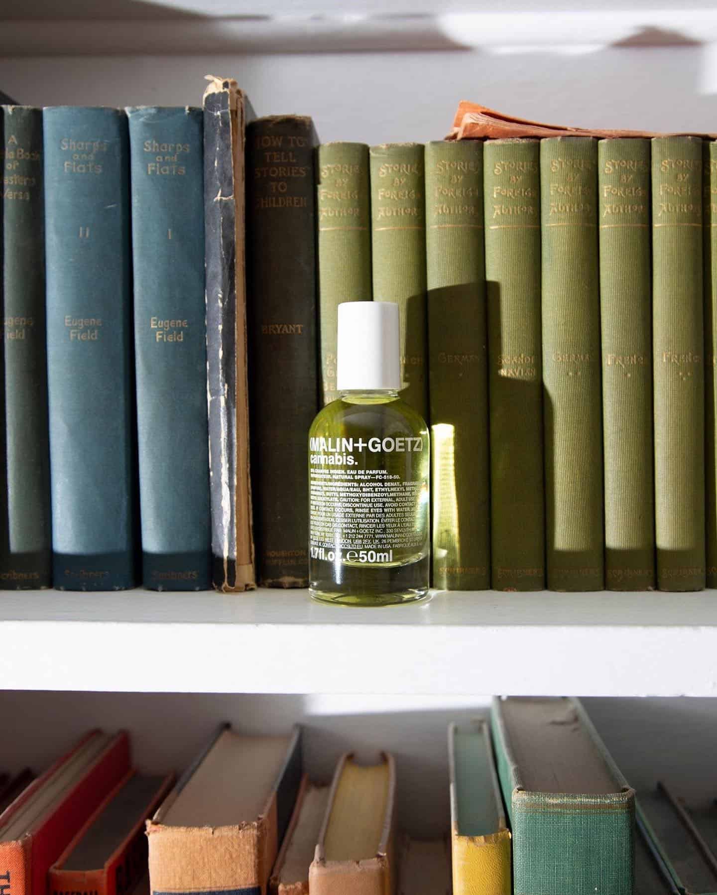 a bottle of malin goetz cannabis on a book shelf