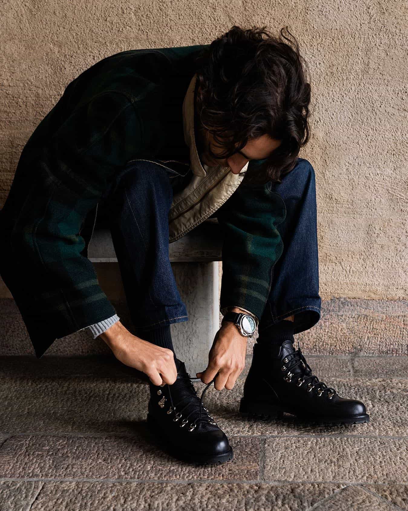 man tying the shoelace of his boots