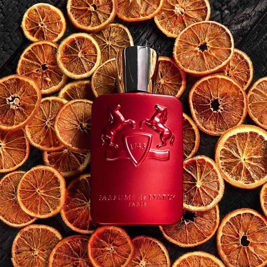 a bottle of kalan by parfums de marly on top of dehydrated orange slices
