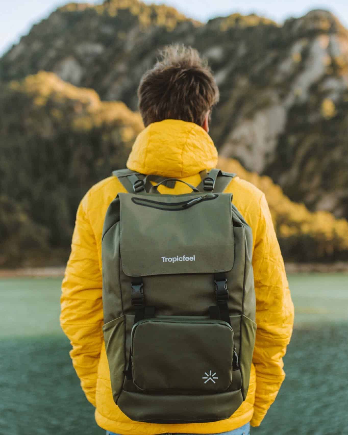 man wearing a yellow jacket and carrying a tropicfeel backpack