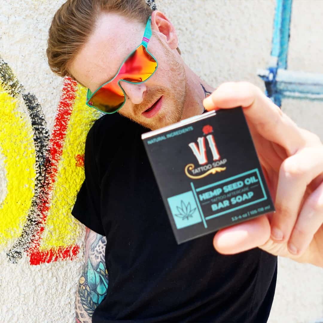 man with sunglasses holding a bar of VI tattoo soap