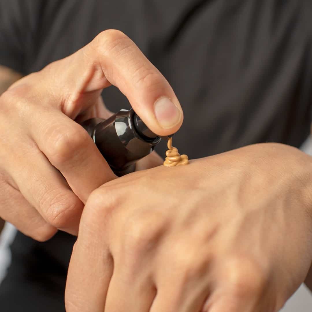 man applying foundation on hands