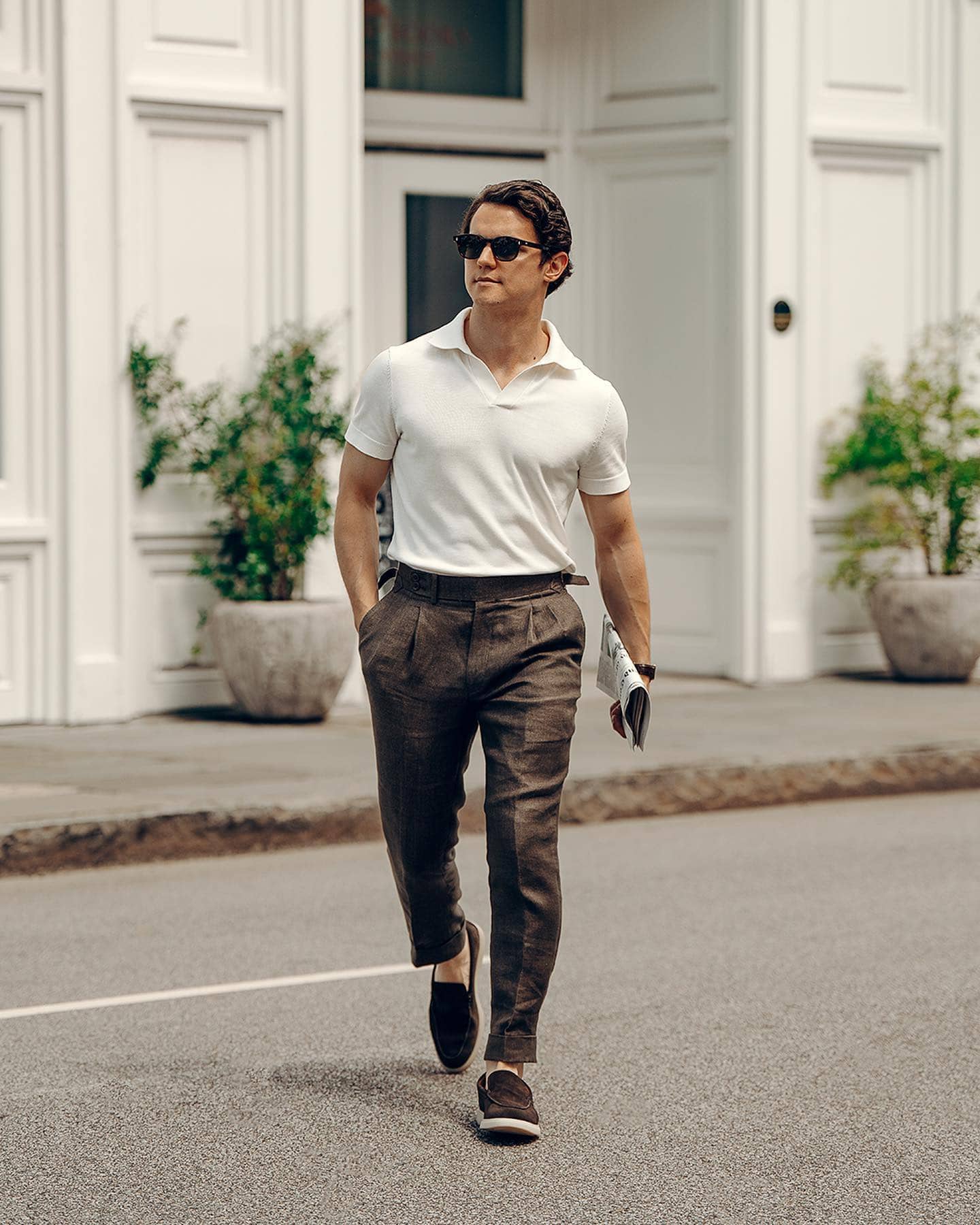 man with a newspaper crossing the street