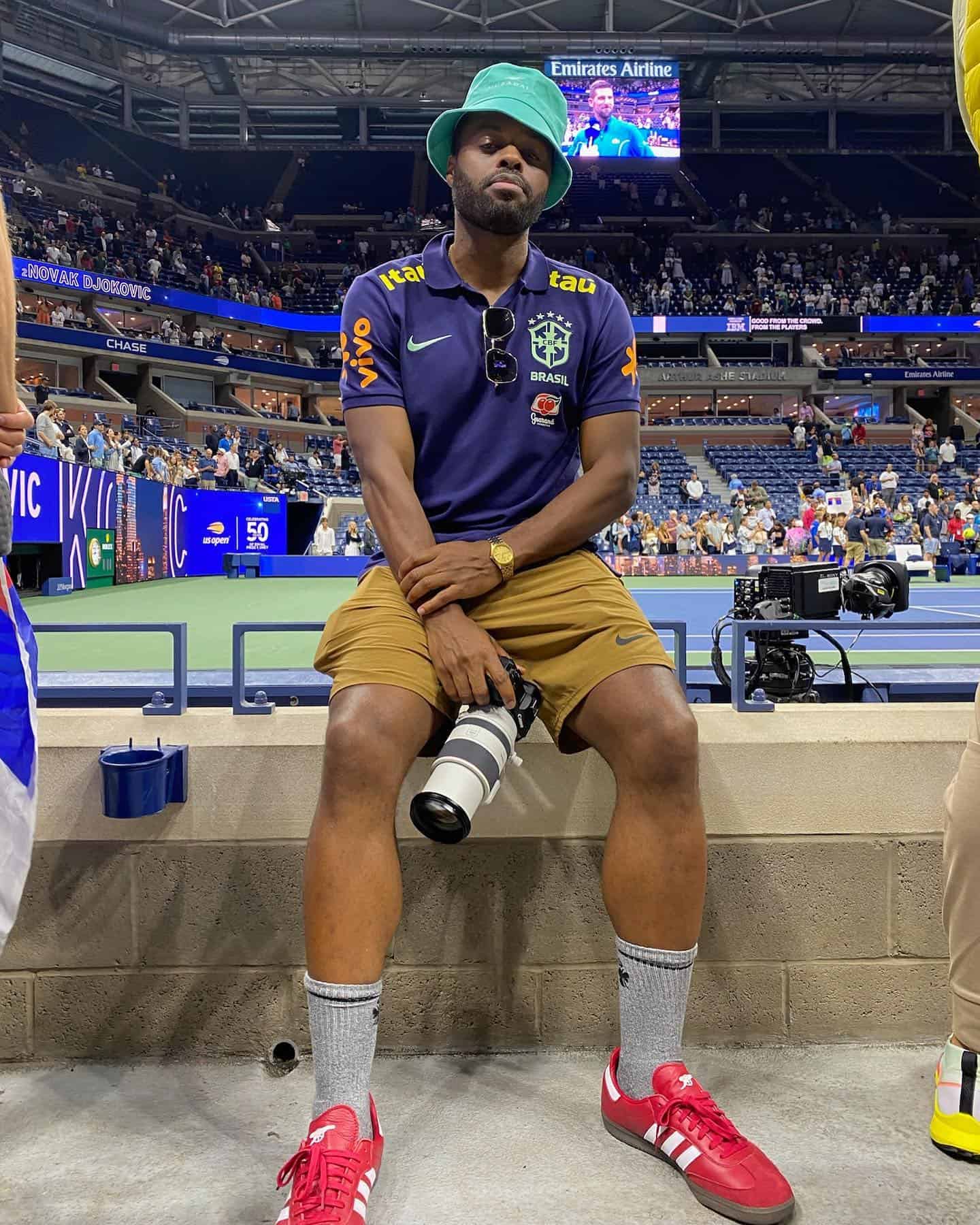man in a bucket hat holding a camera