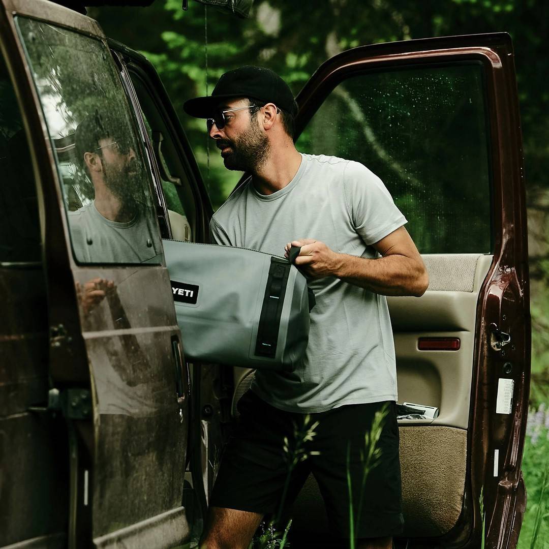 man loading a bag into a car