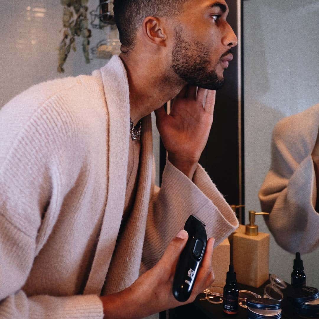 man checking his trimmed beard in the mirror