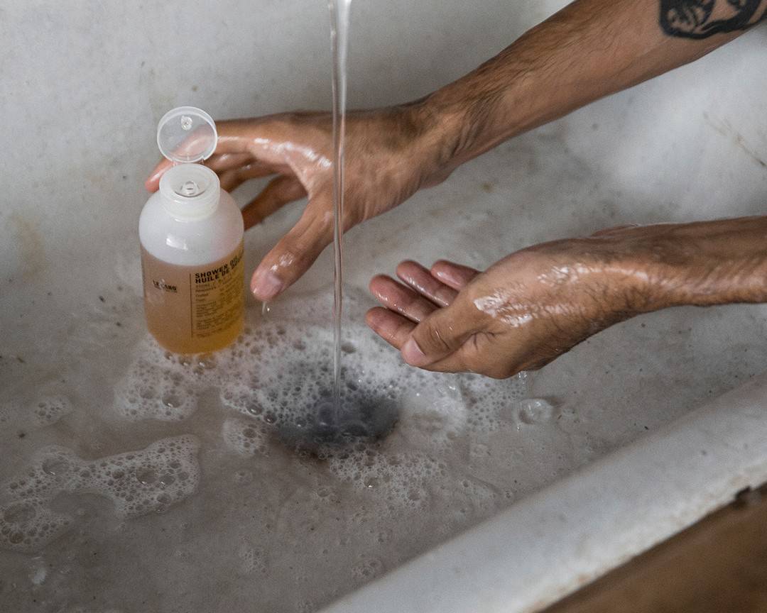 grabbing a bottle of shower gel by le labo