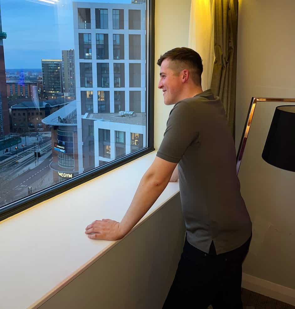 man enjoying the city view from a window