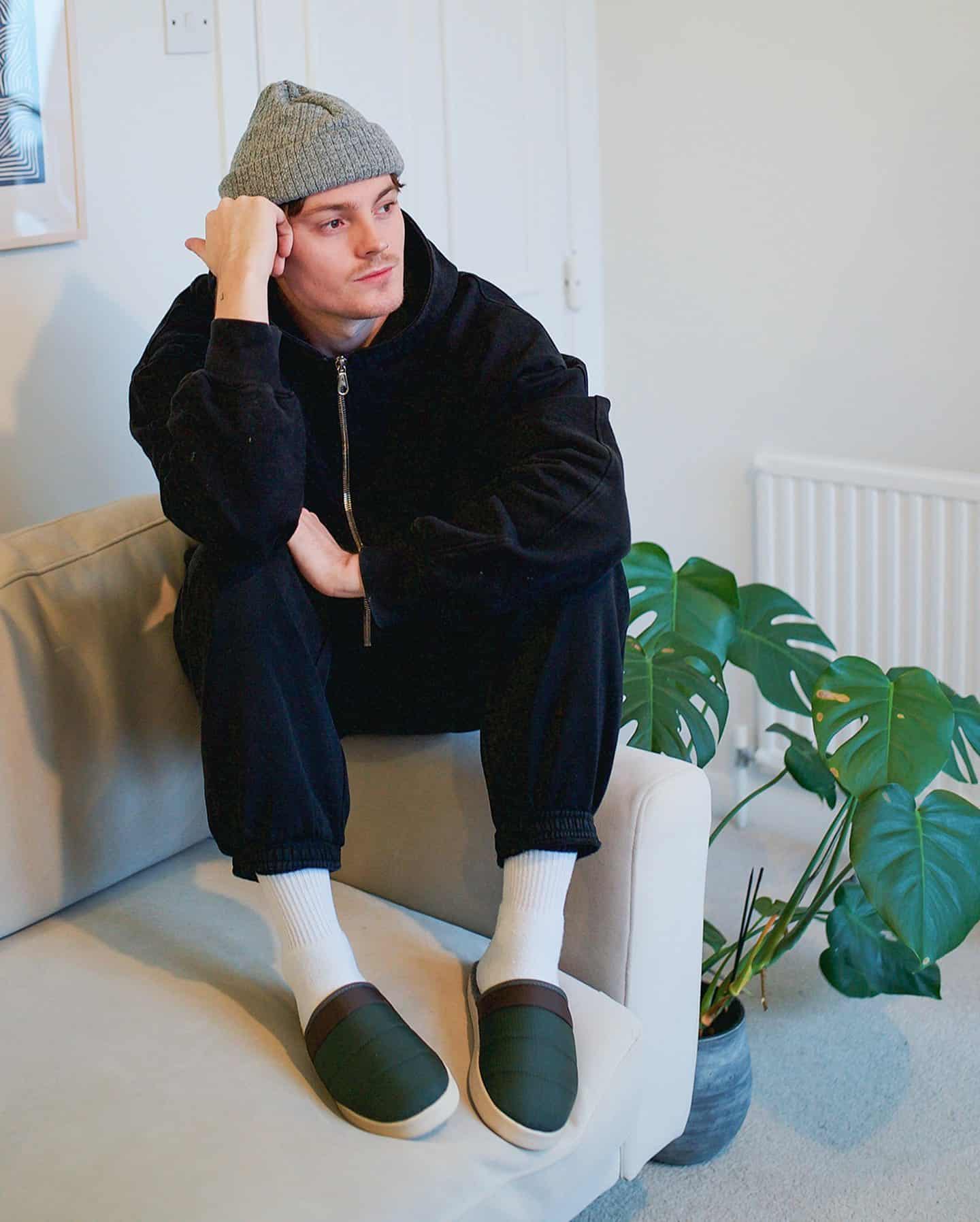 man sitting on a sofas arm rest