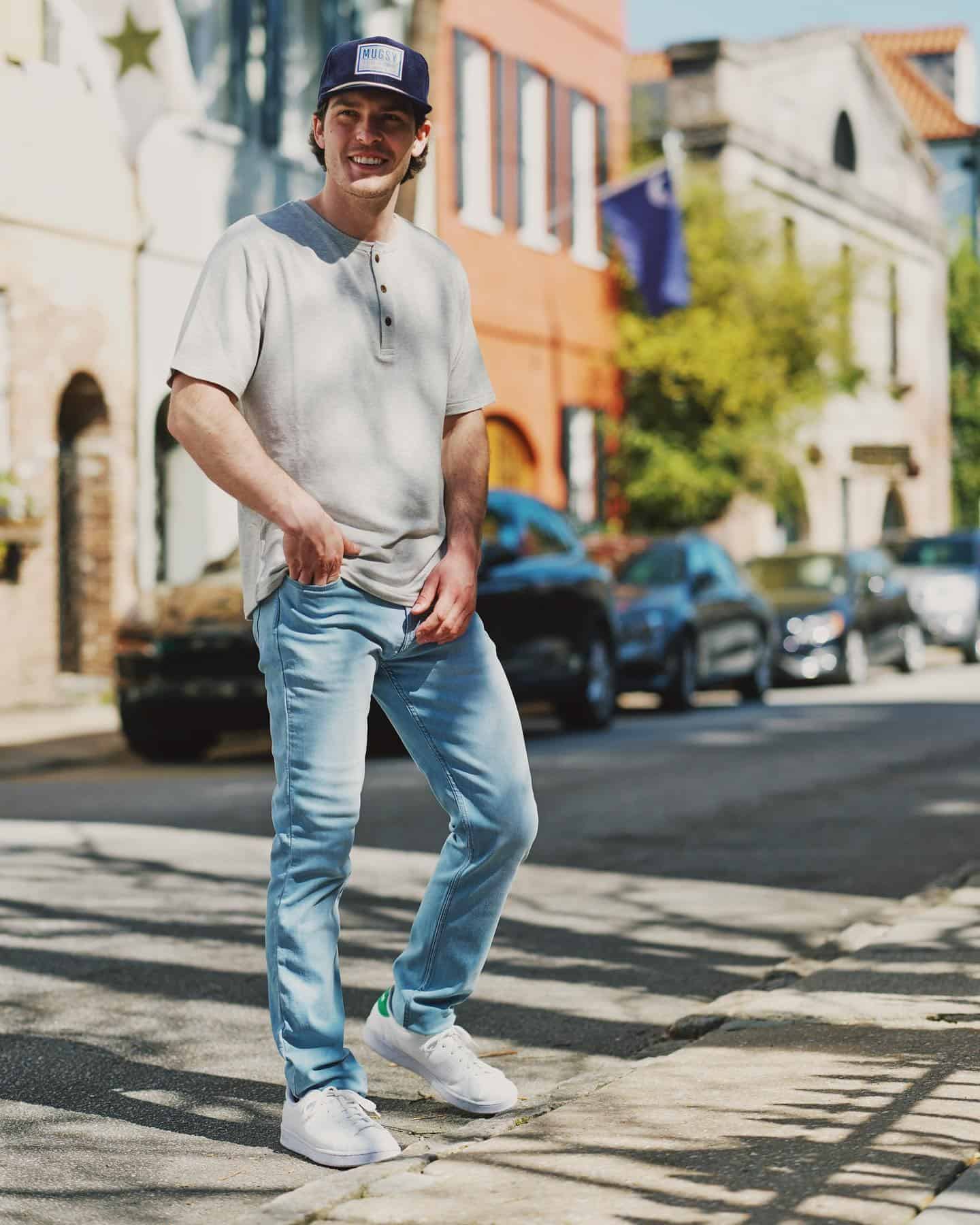 Man smiling standing on a street wearing a Mugsy hat