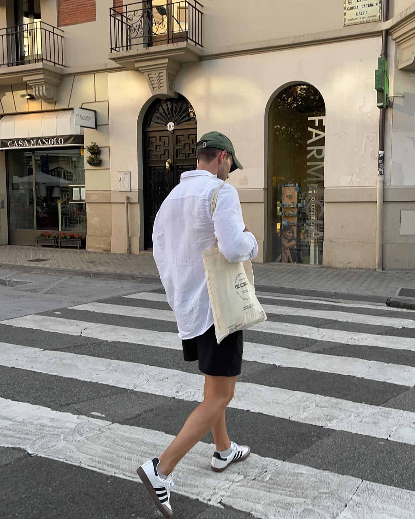 man with a tote bag crossing the street