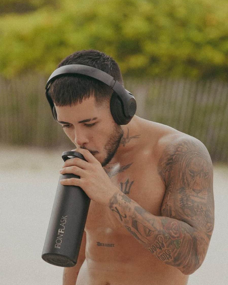 man drinking from an iron flask