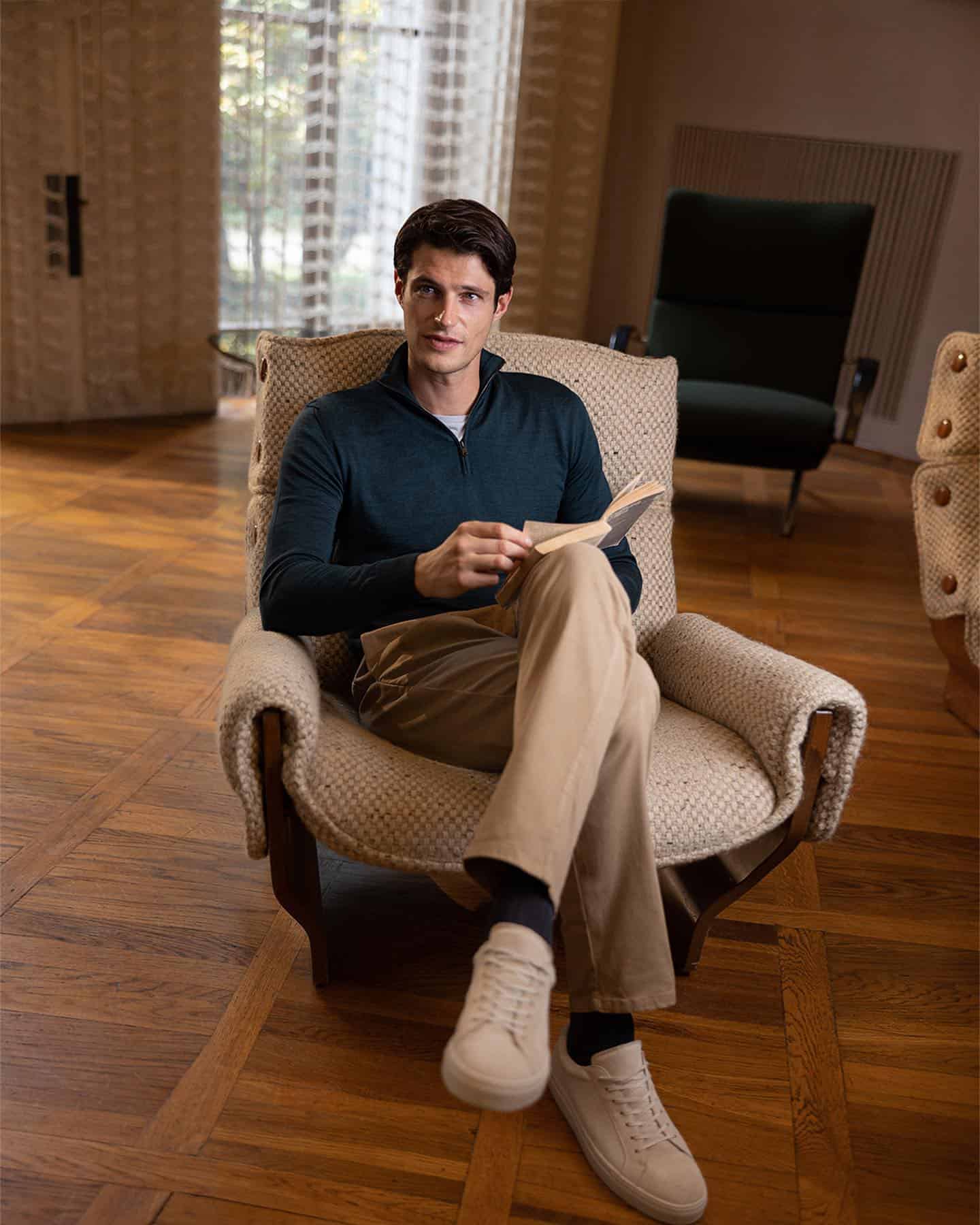 man in a chair holding a book