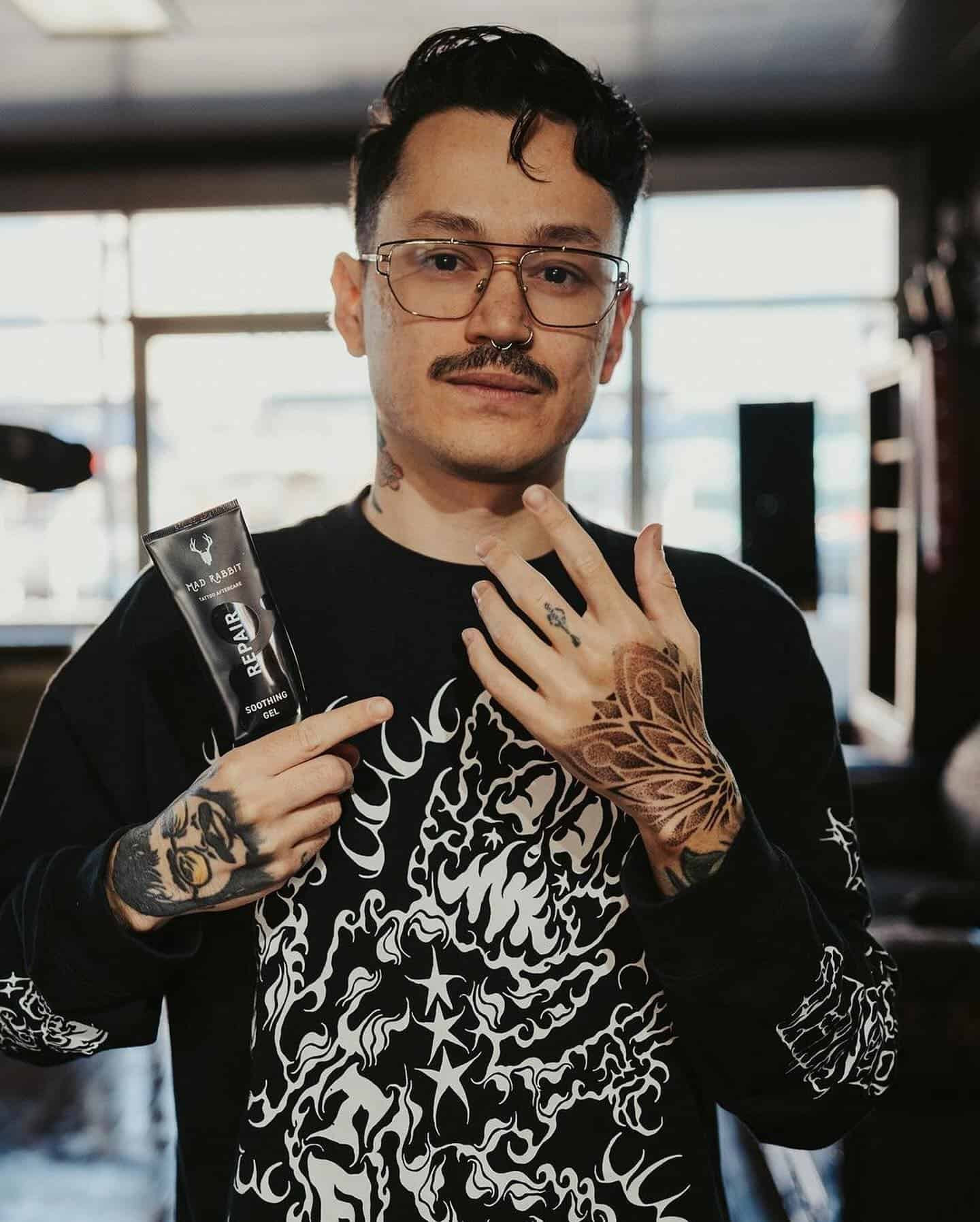 man pointing to a tattoo on his finger