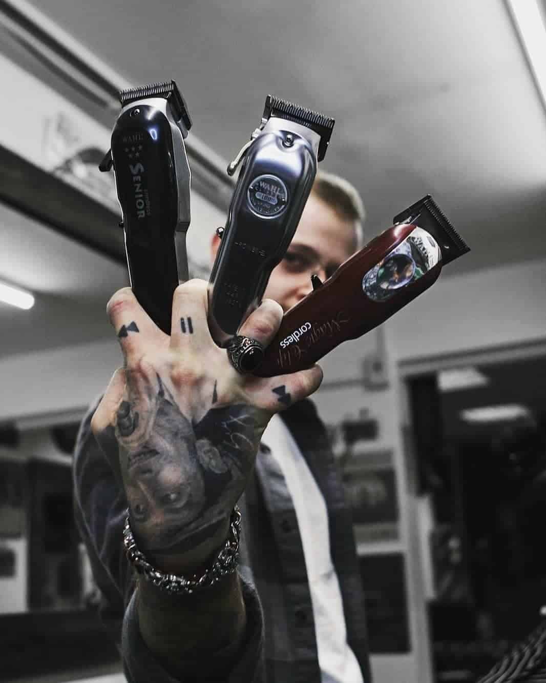 barber holding three wahl clippers