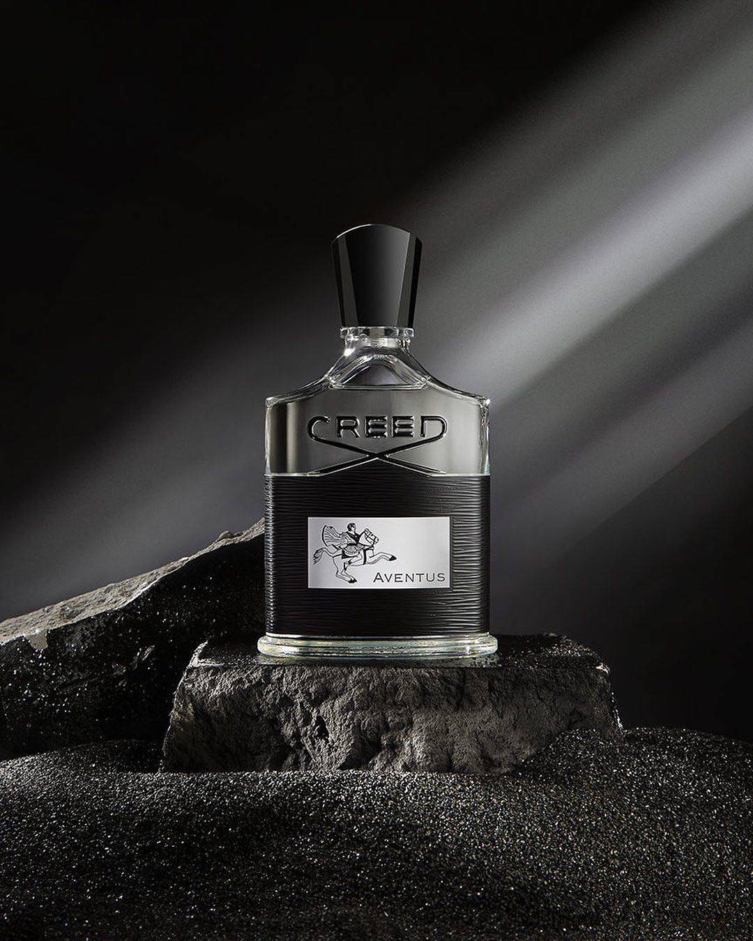 a bottle of creed aventus on top of a rock