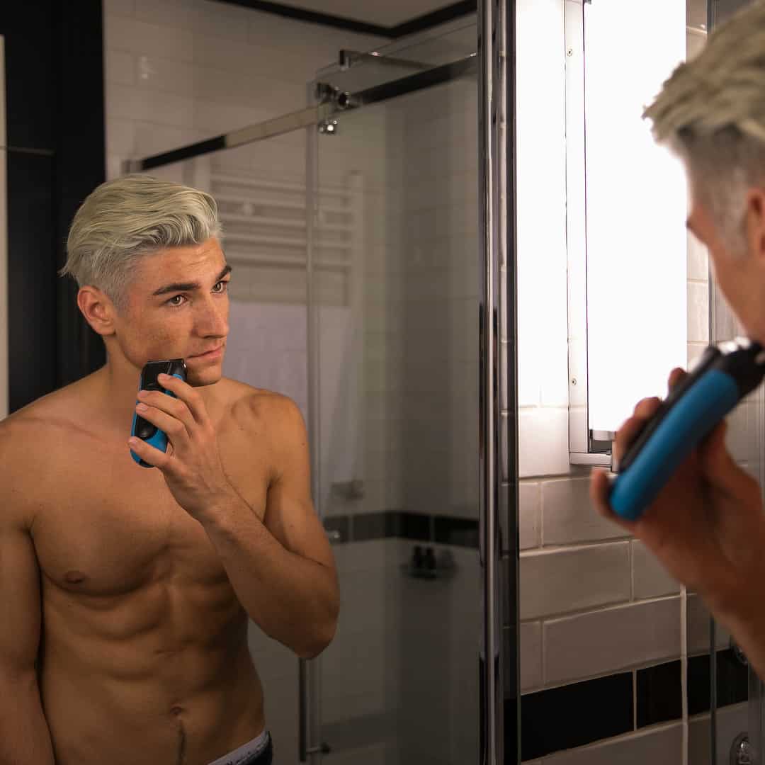 man shaving in-front of a mirror