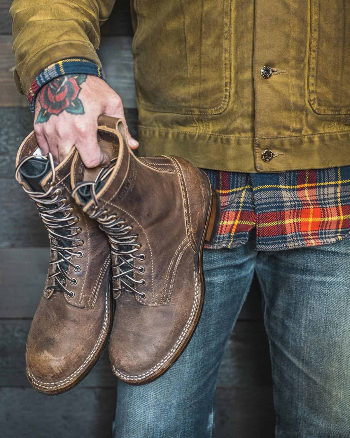 carrying a pair of leather work boots