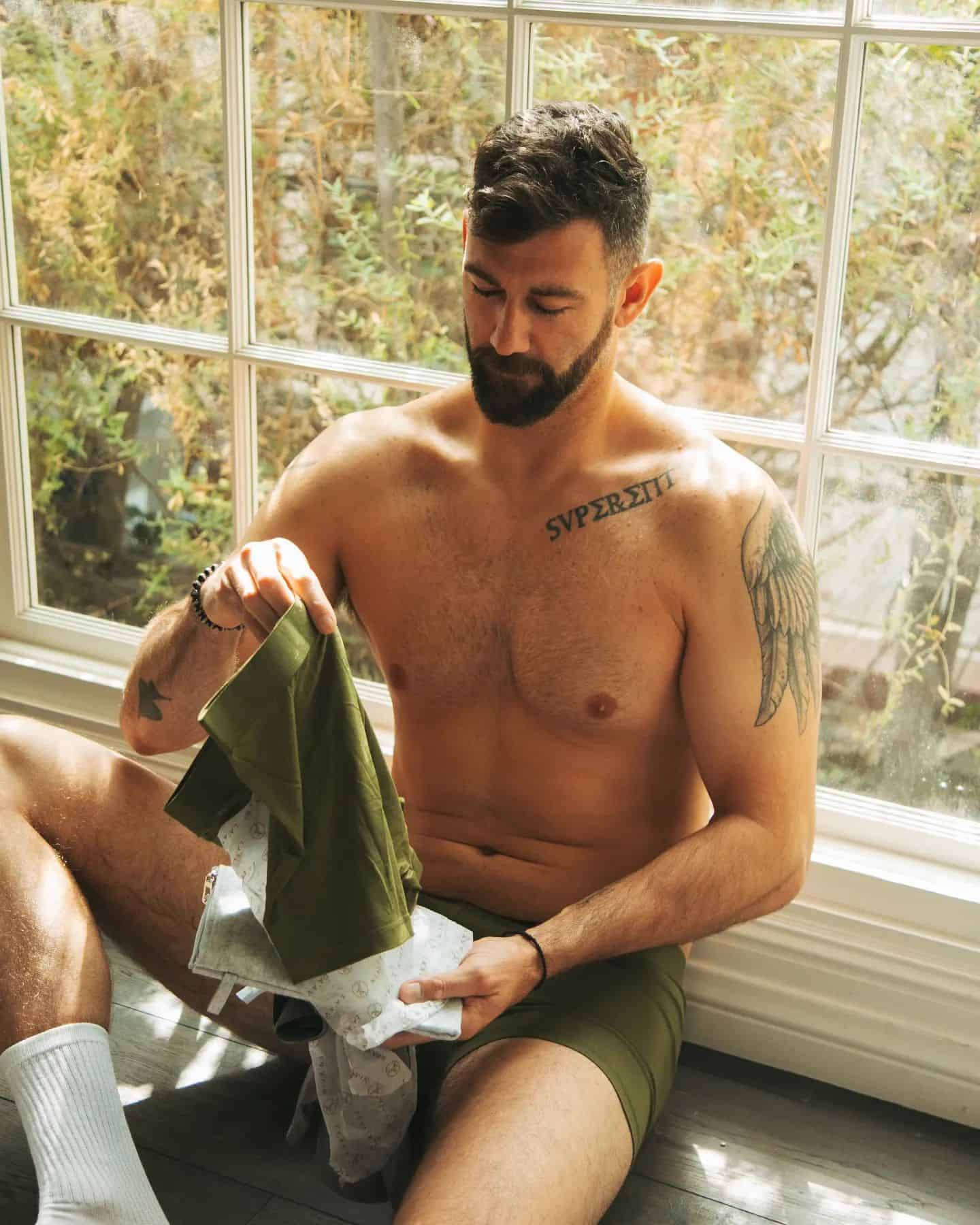man pulling out an olive colored underwear from a bag