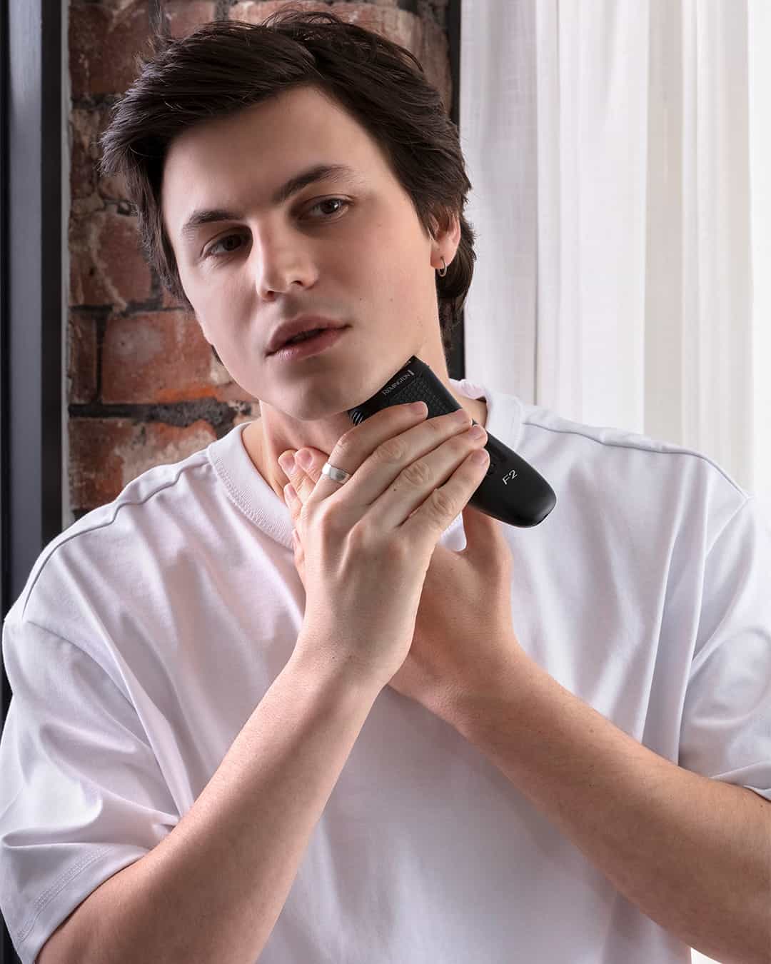 a young man using a foil shaver