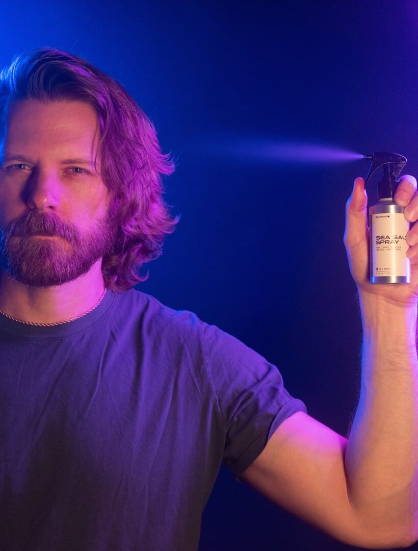 Man spraying sea salt spray on hair