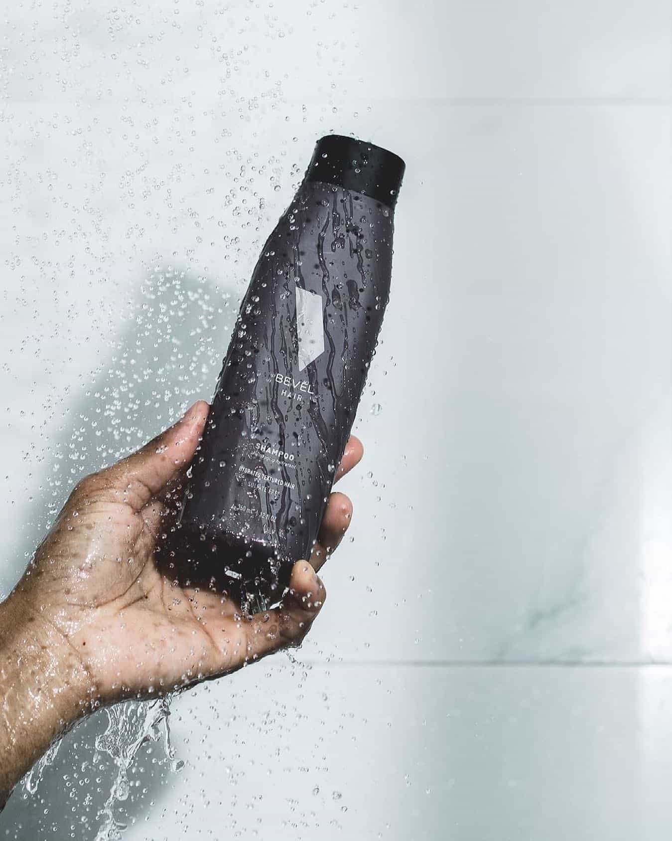 holding a bottle of bevel shampoo