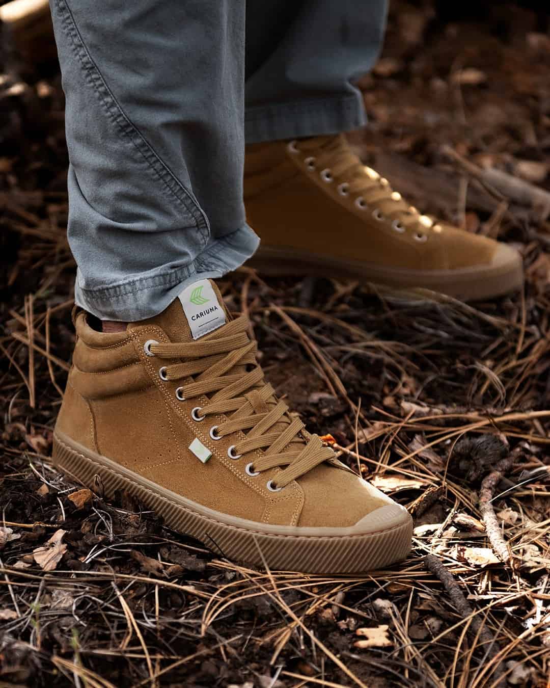 wearing a pair of cariuma high top suede sneakers