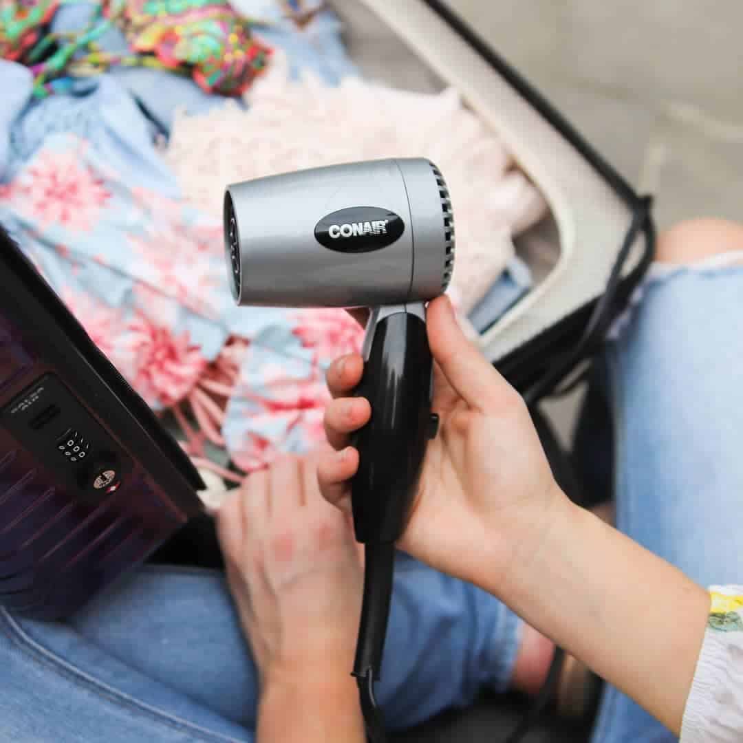 holding a compact hair dryer by conair