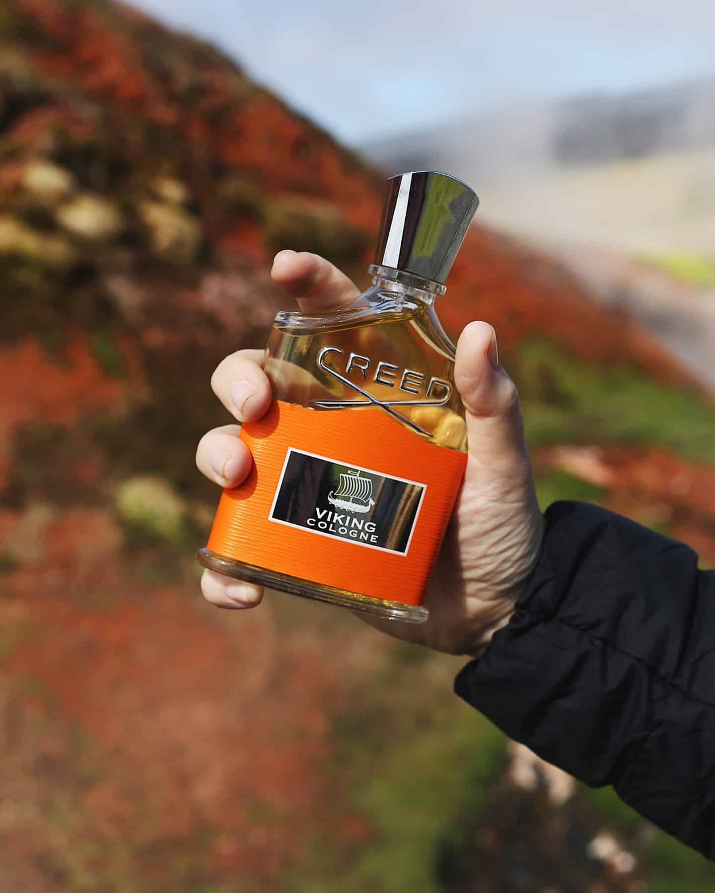 holding a bottle of creed viking