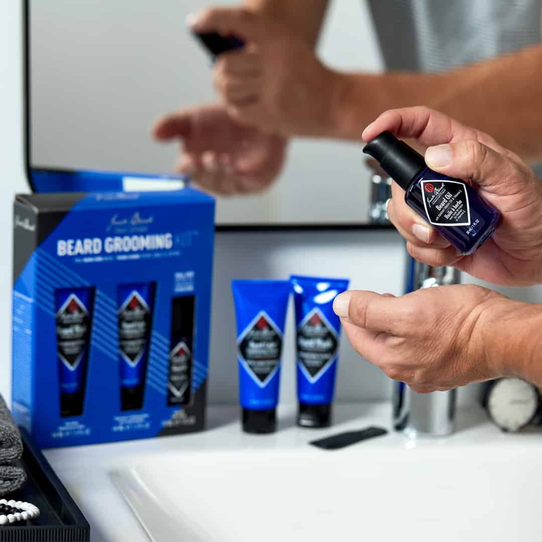 man spraying beard oil to hands