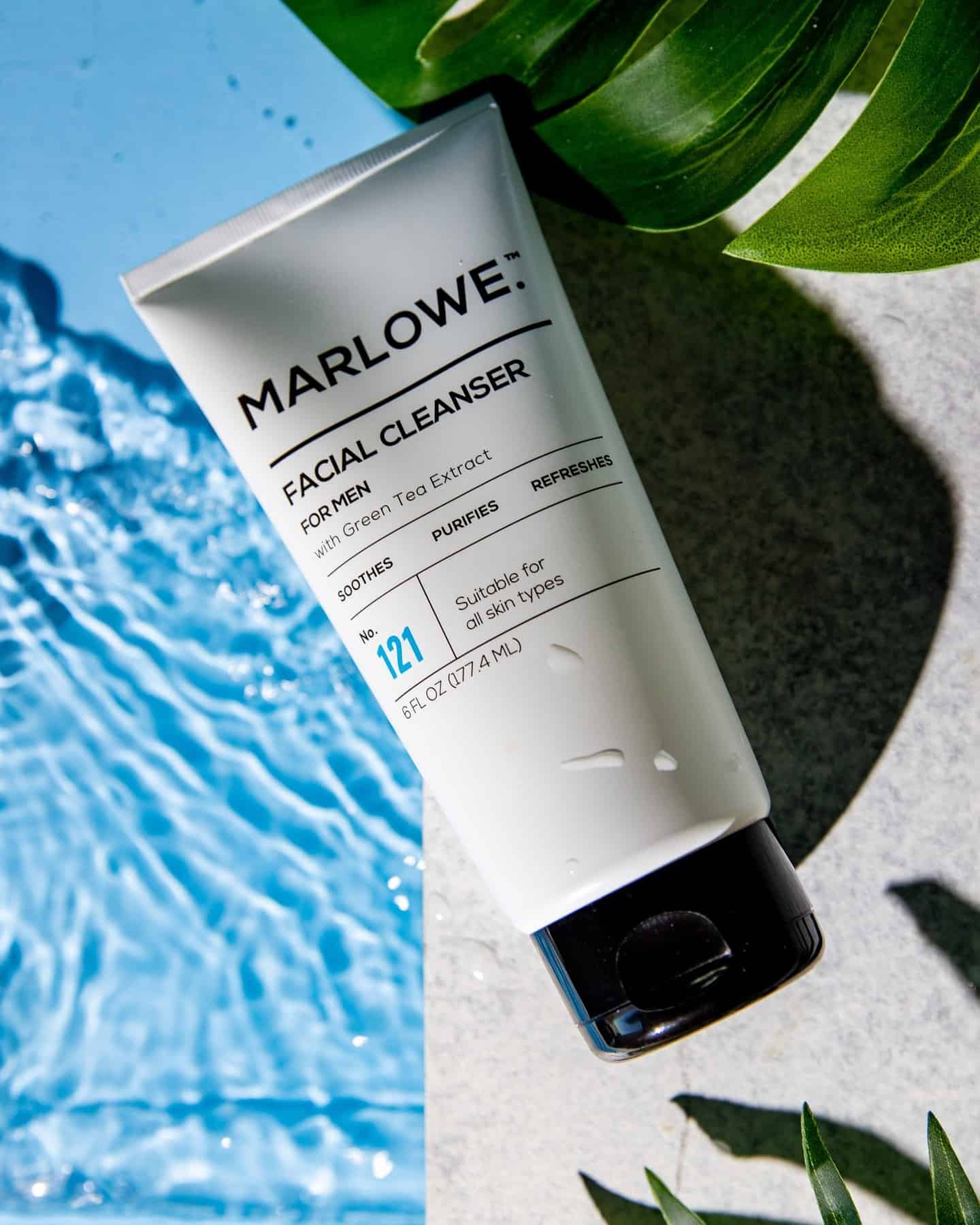 a tube of facial cleanser for men by the pool