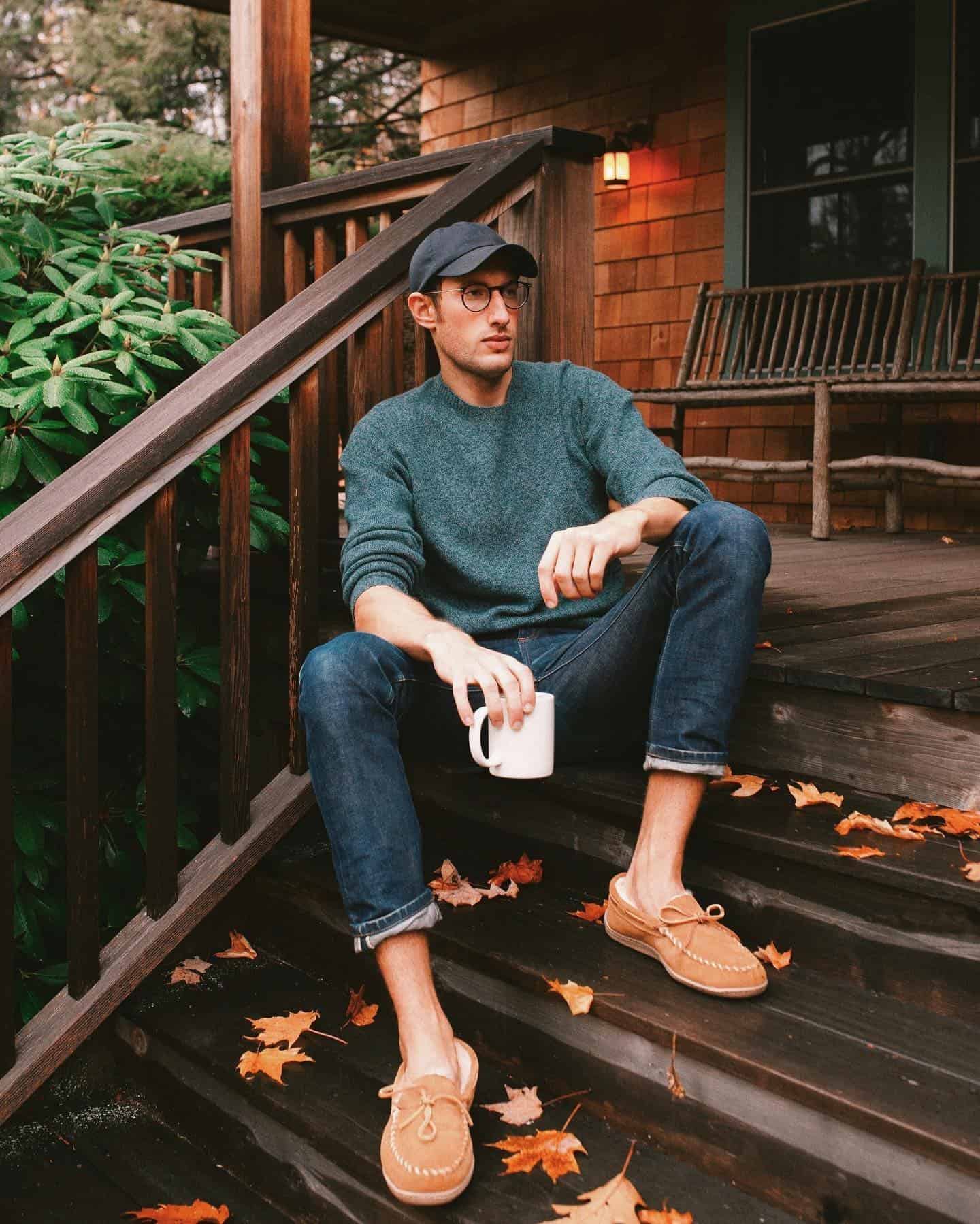 man sitting on the stairs holding a cup of coffee