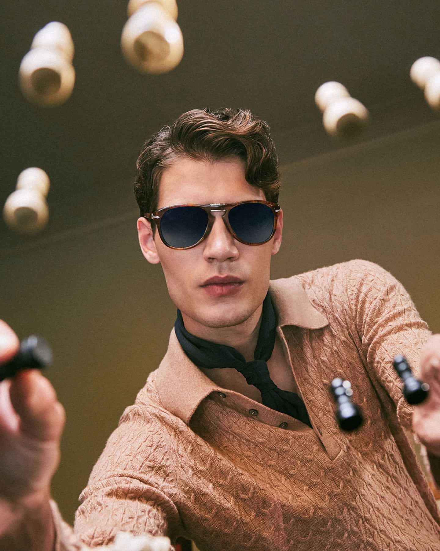 man with sunglasses holding a chess piece