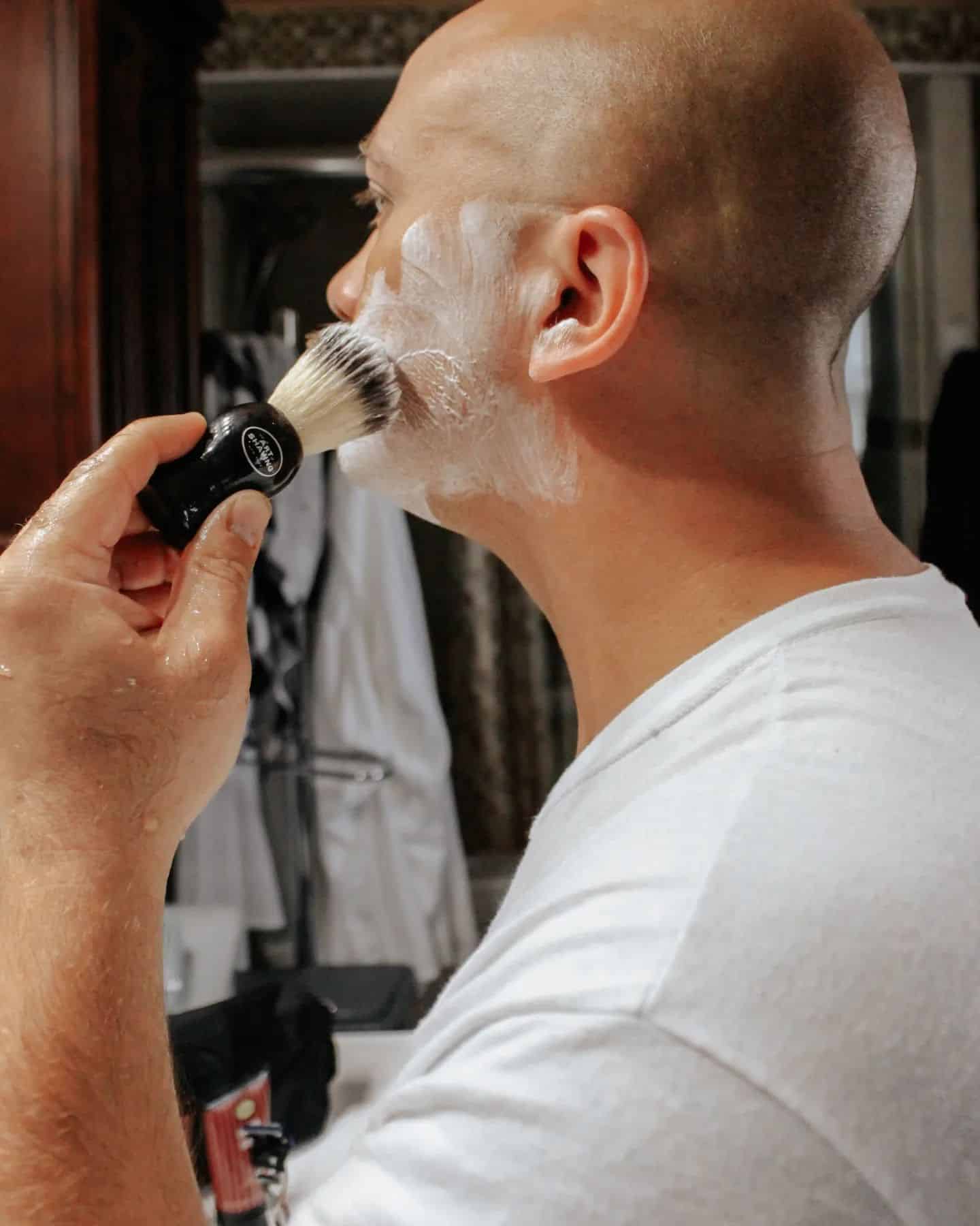 man applying shaving cream on face