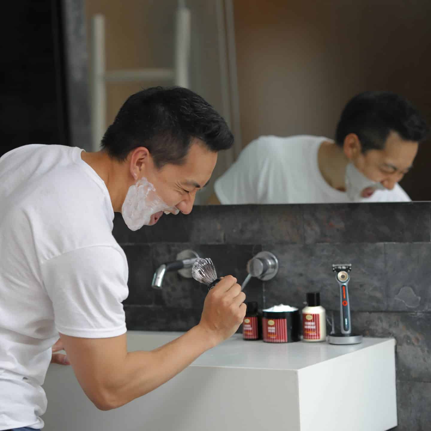 man singing with shaving brush as mic
