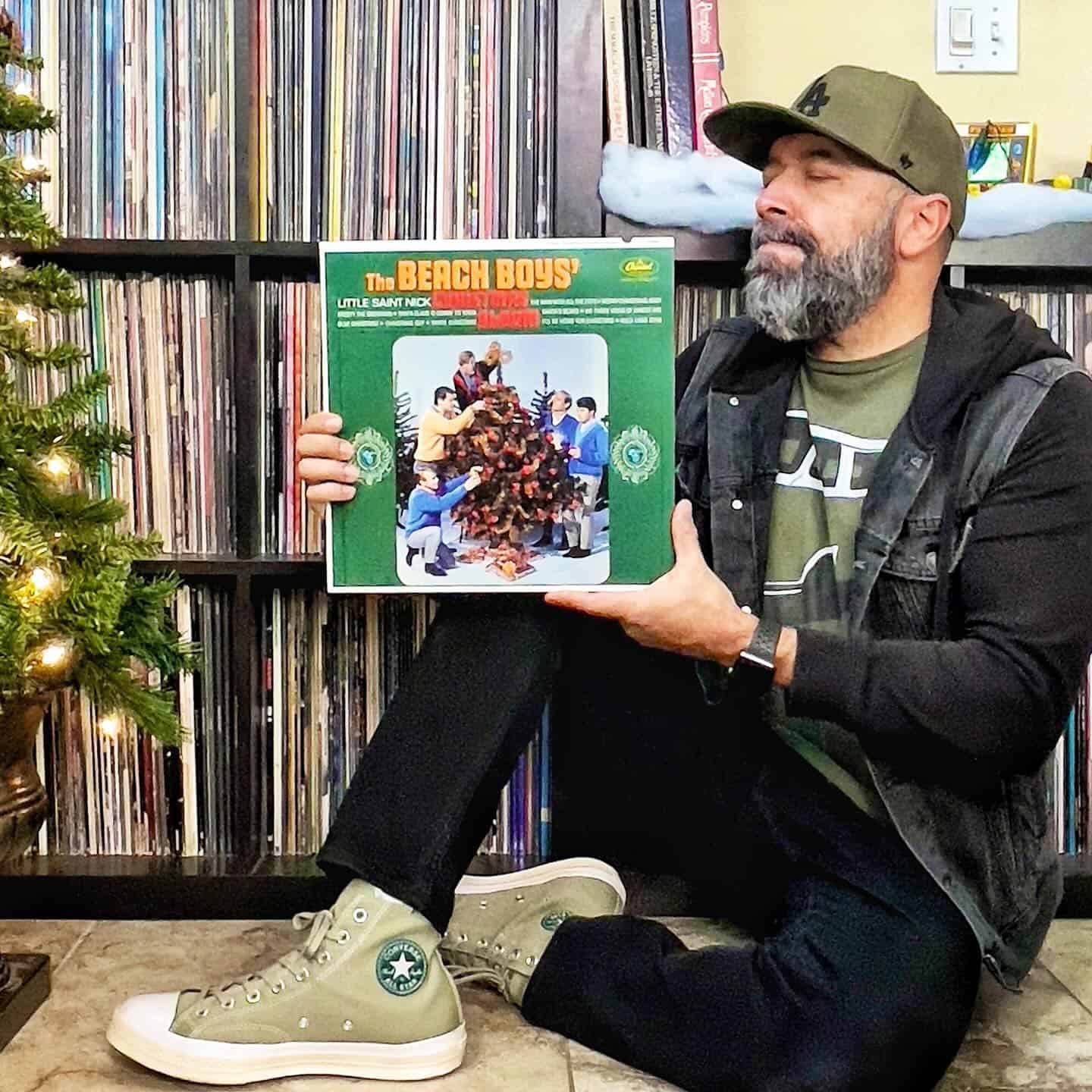 man holding a vinyl record by the beach boys