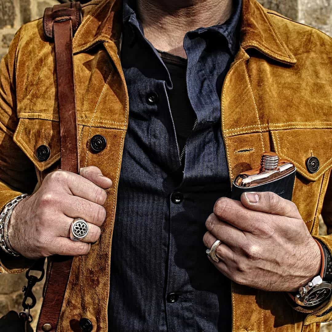 man carrying a shoulder bag and a flask