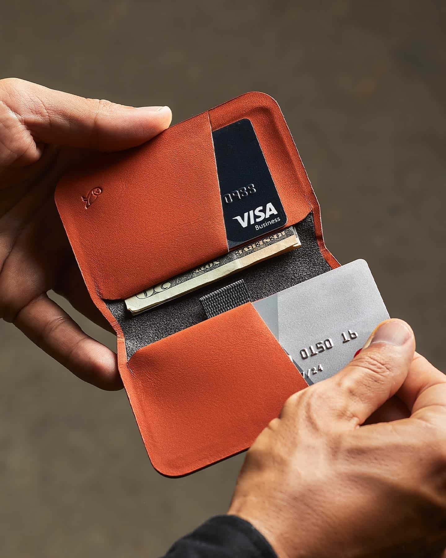 pulling out a visa card from a slim wallet by bellroy