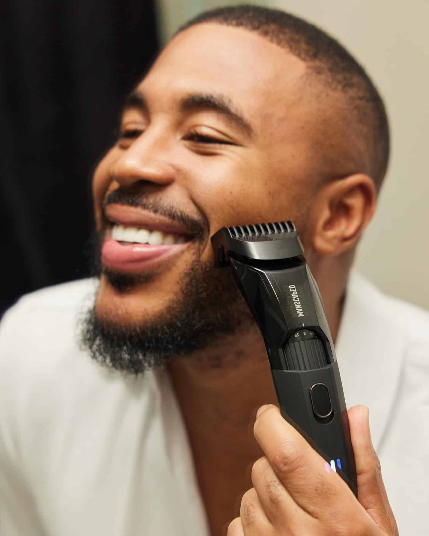 man happily trimming his beard