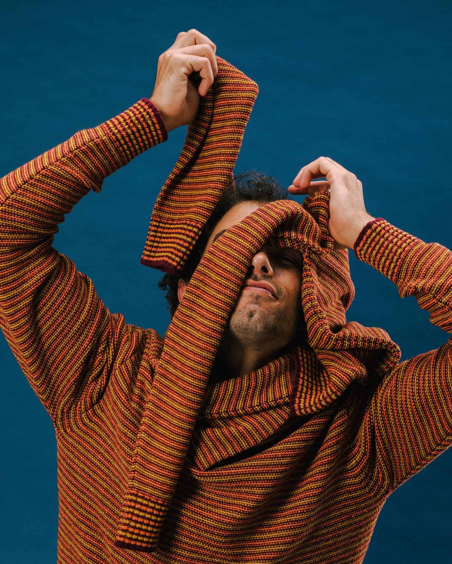 man covering his face with a sweater