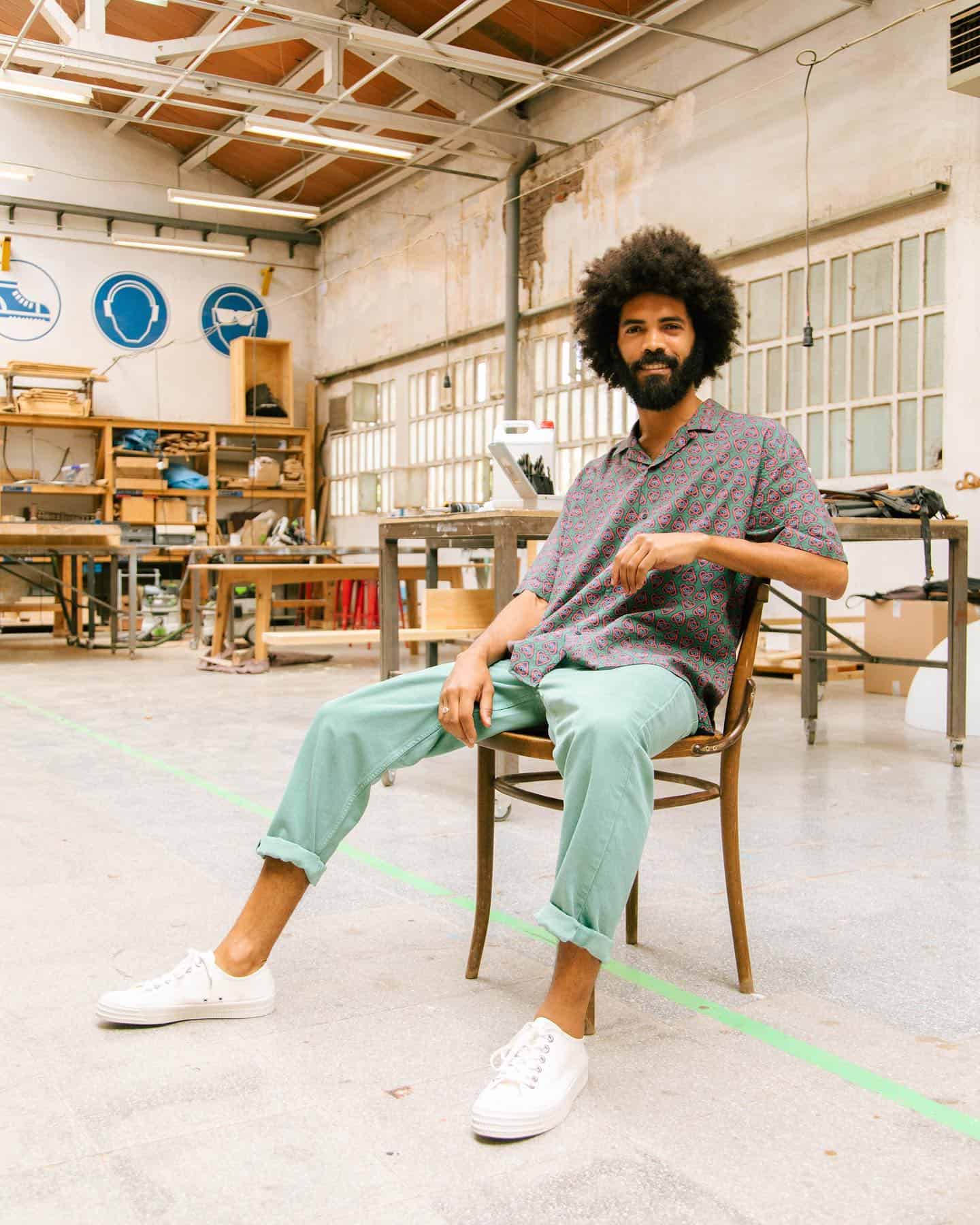 man with curly hair sitting on a chair