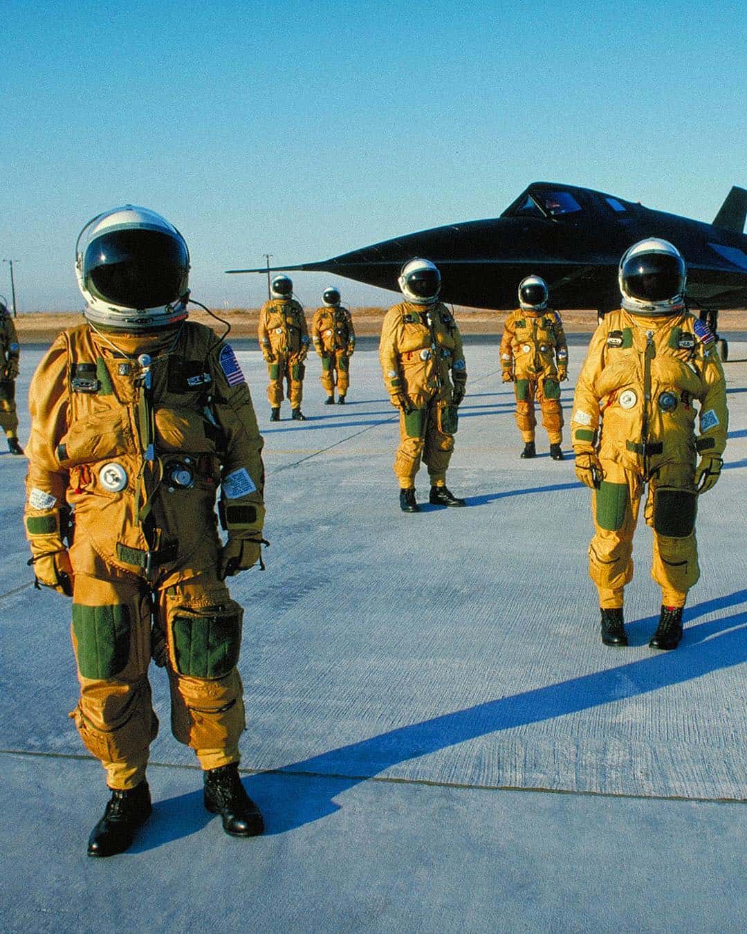a group of men in flightsuits
