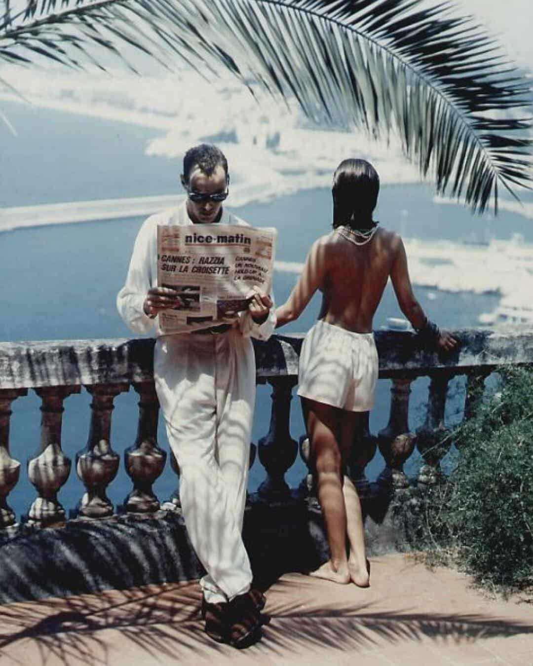 man reading a paper beside a half naked woman