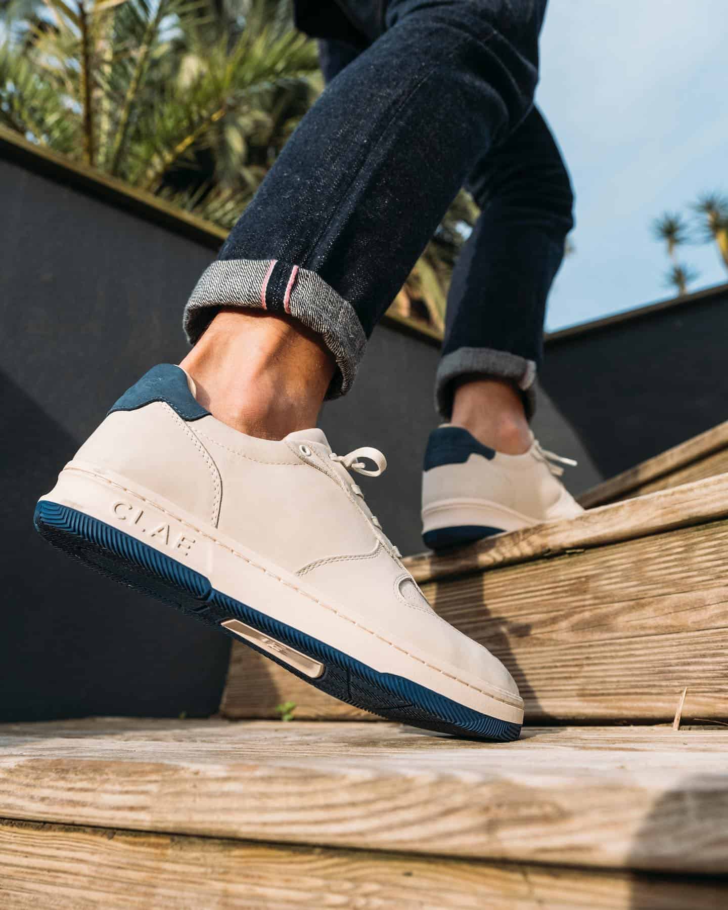 going up a wooden stairs with a pair of white sneakers