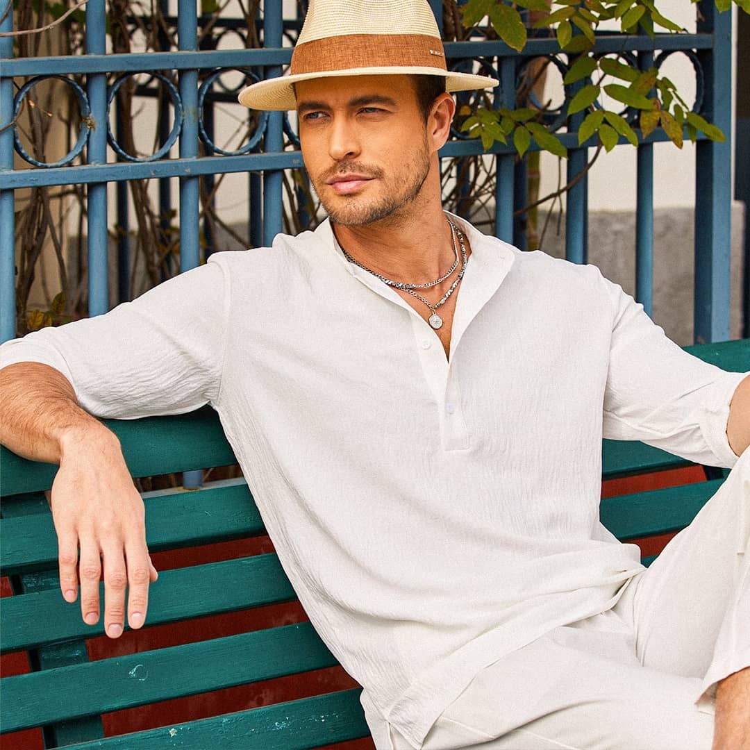 man sitting on a bench wearing a long sleeved henley shirt